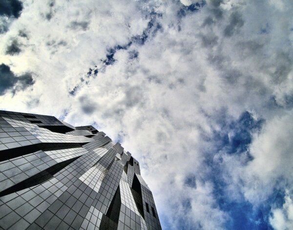 Dc tower in vienna, seen from below, in the bottom left corner, clouds in the rest of the picture